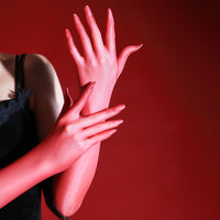 Close-up of a red sheer glove with a black lace cuff resting on a bare thigh thumbnail