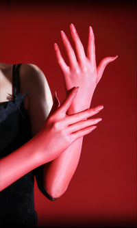Red sheer opera gloves with fingers interlaced against a deep red background thumbnail