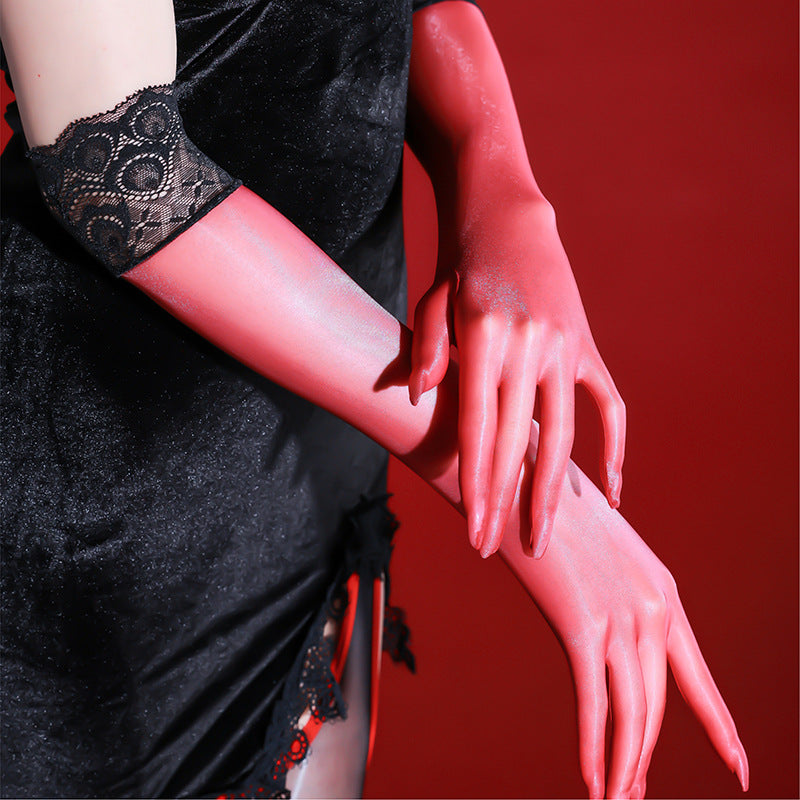 Close-up of black sheer five-finger gloves with a black lace cuff on a deep red backdrop