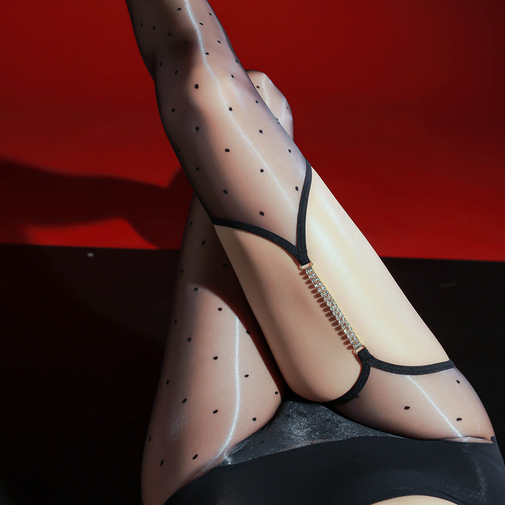 Legs crossed in the IOO&SILK polka-dot sheer stockings and crystal garter strap, model reclining